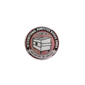 May include: A round pin with a red and white design. The pin features a black and white illustration of a dumpster with the text "International Dumpster Divers Union, Local 86, Means By No Means".