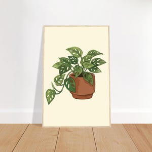 Peut inclure: Une impression d'art verticale encadrée représentant une illustration stylisée d'une plante Monstera adansonii avec des feuilles vertes perforées dans un pot couleur terre cuite, sur un fond crème clair uni dans un cadre en bois fin.