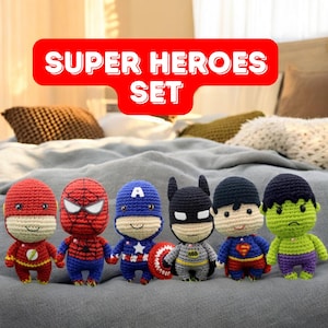 May include: A set of six crocheted superhero toys. The toys are all different colors and have different superhero symbols on their chests. The toys are sitting on a bedspread.