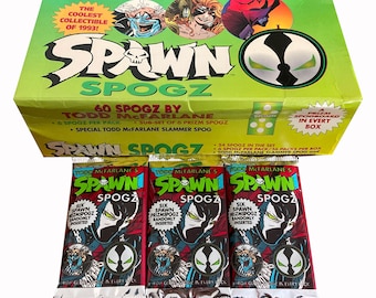 May include: A green, yellow, and red box with the words "Spawn Spogz" on the front. The box contains 60 trading cards featuring the Spawn character. The box also includes a special slammer card.