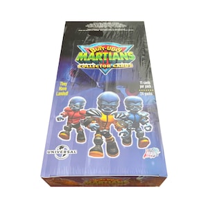 May include: A box of Butt-Ugly Martians collector cards. The box features three cartoon characters with blue skin and different colored outfits. The box is blue and purple with the text "Butt-Ugly Martians Collector Cards" in white. The text "They Have Landed!" is also on the box.