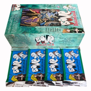 Könnte beinhalten: Ein Sammelkartenset "Bone: Dragonslayer". Die Box ist türkis mit dem "Bone"-Logo und Karteninformationen. Darunter befinden sich vier ungeöffnete Packungen mit blau-grüner Verpackung, Charakterillustrationen und dem "Bone: Dragonslayer"-Logo.