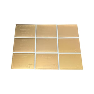 May include: Nine gold-colored rectangular cards with embossed text. The cards are arranged in a three-by-three grid. Each card features text, with the words "STAR TREK" visible on some. The cards have a metallic sheen.