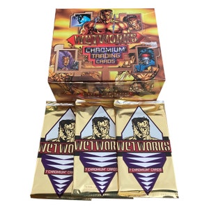 May include: A box of Wetworks Chromium Trading Cards. The box is gold and black with a picture of a muscular man on the front. The box is open and there are three packs of cards inside. Each pack is gold with a picture of a muscular man on the front and the text "Wetworks" in a purple and white font. Each pack contains 7 Chromium cards.