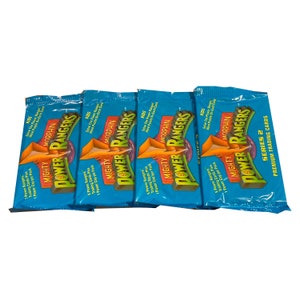 May include: Four blue packs of "Mighty Morphin Power Rangers" trading cards. Each pack includes trading cards and a Power Cap. The packaging features the Power Rangers logo and the text "Series 2 Premium Trading Cards."