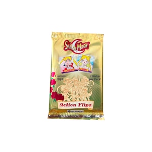 May include: A gold foil pack of Sailor Moon Action Flipz trading cards. The pack features the Sailor Moon logo, images of characters, and the text "Action Flipz". The pack contains 4 Action Flipz and 1 sticker per pack.