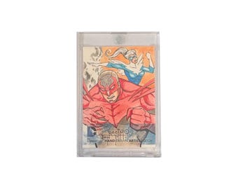 DC Comics: The New 52 original hand-drawn artist sketch card by Jon Racimo in heavy duty plastic holder. Produced by Cryptozoic.