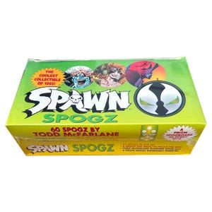 May include: A sealed box of Spawn Spogz collectible cards. The box is primarily green and yellow, with the Spawn logo and character illustrations. Text on the box includes "The Coolest Collectible of 1993!" and "60 Spogz by Todd McFarlane."