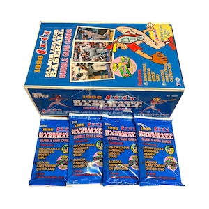 May include: A blue box of 1996 Bazooka Major League Baseball bubble gum cards with individual packs. The box and packs feature baseball players and the Bazooka logo. Each pack contains bubble gum and cards.