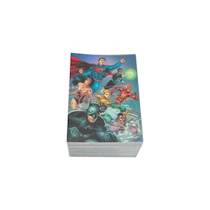 May include: A rectangular deck of trading cards featuring a colourful illustration of DC Comics superheroes including Batman, Superman, Wonder Woman, Aquaman, The Flash, and Green Lantern against a blue background with a white border edge.