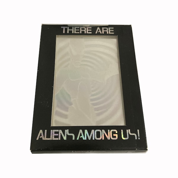 There Are Aliens Among Us. Limited edition boxed set of 8 multi-colored holographic alien trading cards. Box shows some wear but is sealed.
