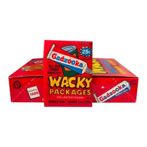 Puede incluir: Una caja expositora de cartón rojo con pegatinas y chicle Wacky Packages de 1988. La caja muestra un gráfico de un tubo Gadzooka, el texto "Wacky Packages", "All New 1988", "25c", "36 ct" y "Gomme balloune" en inglés y francés.