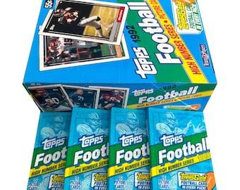May include: A box of 1992 Topps Football cards. The box is blue and green with the Topps logo and the words "Football" and "High Number Series" printed on it. The box is surrounded by five packs of cards, each with a blue and green design and the words "Topps Football" printed on it.