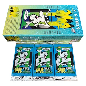 Könnte beinhalten: Eine Schachtel Bone Serie 2 Sammelkarten mit drei Packungen davor. Die Schachtel ist blau und grün mit dem Bone-Logo und -Charakter. Jede Packung ist blau mit dem Bone-Charakter und dem Text "Serie 2".