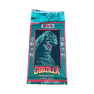 May include: A green, red, and white trading card pack featuring Godzilla. The pack has Japanese text that reads "Godzilla" and "Space Battleship Yamato". The pack is for Chromium Trading Cards.
