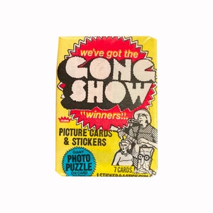O pacote de cera vintage Gong Show. 7 cartões + 1 adesivo. 1977 Chuck Barris Produções/Fleer. O chiclete está intacto.