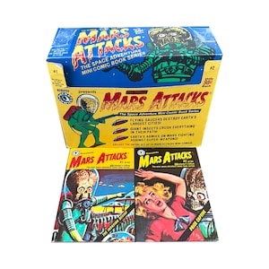 May include: A collection of vintage "Mars Attacks" mini comic books. The box and comics feature colorful illustrations of Martian invaders, flying saucers, and terrified humans. The box reads "The Space Adventure Mini Comic Book Series."