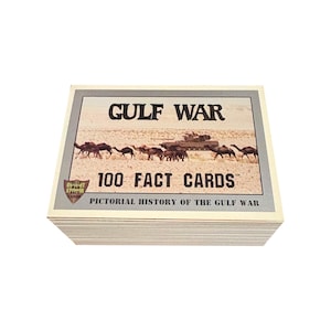 Könnte beinhalten: Ein Stapel Golfkrieg-Fact-Cards. Die oberste Karte zeigt den Text "GULF WAR" über einer Illustration von Kamelen, einem Panzer und einer Wüstenlandschaft. Der Text "100 FACT CARDS" und "PICTORIAL HISTORY OF THE GULF WAR" sind ebenfalls sichtbar.