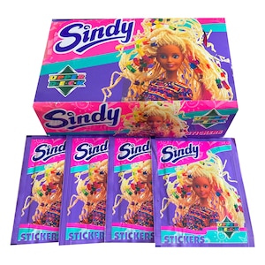 May include: A box of Sindy Upper Deck stickers featuring a doll with long blonde hair and colorful hair ties. The box is purple and pink with the text "Sindy Upper Deck Stickers" printed on it. There are four individual sticker packs in the image, each featuring a different image of the doll.