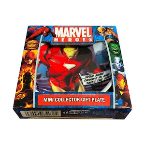 May include: A red and gold Marvel Heroes mini collector gift plate featuring Iron Man. The plate has a white background with a cityscape design. The text on the plate reads "...Iron Man swoops in and saves the day!"