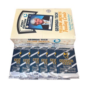May include: A box of Georgia Tech Yellow Jackets trading cards. The box is cream-coloured with the words "First Edition" and "Bobby Cremins" on it. Below the box are several packs of trading cards.