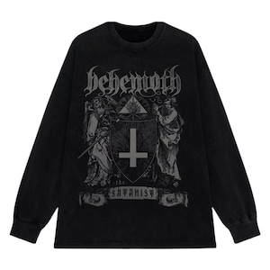May include: Black long-sleeved top with a distressed graphic. The graphic features the word "behemoth" in gothic lettering, a shield with a cross, and the text "the satanist". The top has a crew neck and long sleeves.