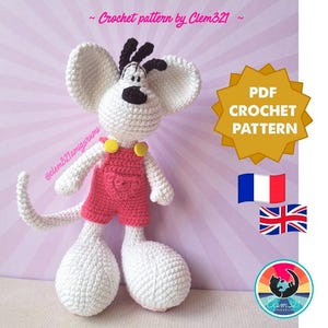 Peut inclure: Une souris crochetée blanche avec de grandes oreilles, des détails noirs et une salopette rose. La souris a une longue queue et de grands pieds. L'image comprend le texte "PDF CROCHET PATTERN" et les drapeaux de la France et du Royaume-Uni.