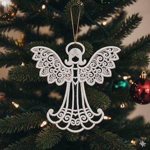 May include: White angel Christmas tree ornament with intricate, openwork detailing. The angel has outstretched wings, a halo, and a heart-shaped design on the chest. It hangs from a gold string against a backdrop of a decorated Christmas tree.
