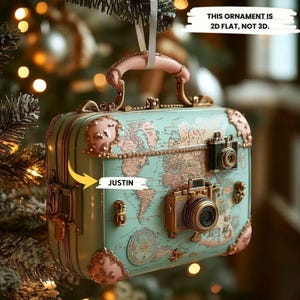 Adorno navideño plano 2D con temática de viajes: minimaleta con mapa del mundo y cámaras vintage para decorar con pasión por los viajes.