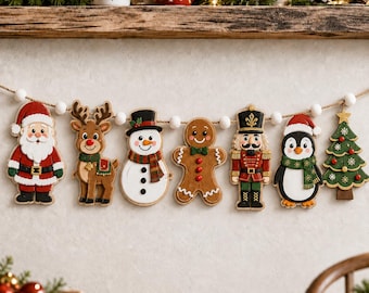 May include: A Christmas garland featuring seven hanging wooden ornaments strung on a white pom-pom rope. The ornaments depict Santa Claus, a reindeer, a snowman, a gingerbread person, a nutcracker, a penguin, and a decorated Christmas tree.