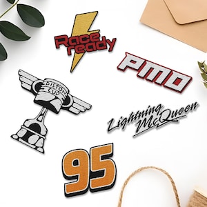 May include: Five embroidered patches featuring the characters from the movie Cars. The patches include a yellow lightning bolt with the text "Race Ready", a red and white trophy with the text "Piston Cup", a red and white patch with the text "P.M.D", a black and white patch with the text "Lightning McQueen", and an orange number "95" patch.