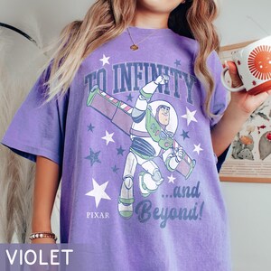 Puede incluir: Camiseta violeta con Buzz Lightyear de Toy Story de Pixar. El dise&ntilde;o incluye la frase "TO INFINITY ...and Beyond!" con gr&aacute;ficos de estrellas. La camiseta tiene un corte holgado.