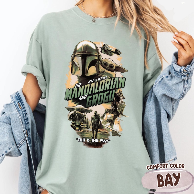 Puede incluir: Camiseta verde claro Comfort Colors con un gr&aacute;fico de Star Wars de "The Mandalorian and Grogu". El dise&ntilde;o incluye el casco del Mandaloriano, Grogu y la frase "This is the Way".