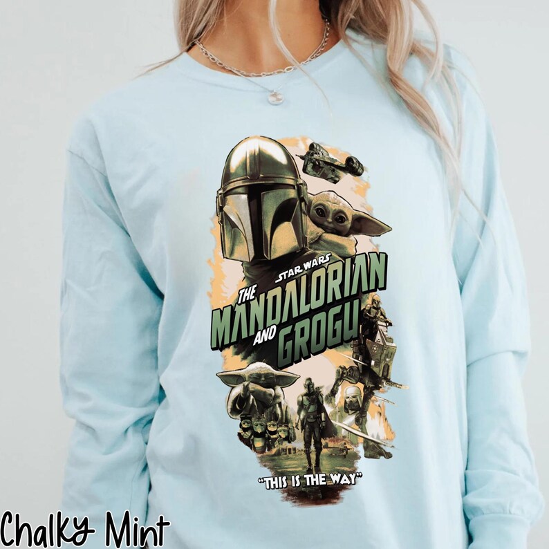 Puede incluir: Camiseta de manga larga azul claro con un gr&aacute;fico de la serie Star Wars, "The Mandalorian and Grogu". El dise&ntilde;o incluye al Mandaloriano, Grogu y el texto "THIS IS THE WAY".