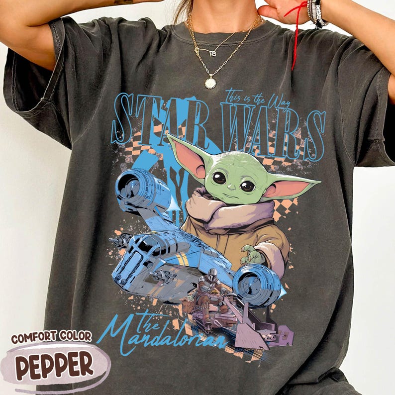 May include: Dark gray Comfort Colors t-shirt featuring a graphic of Grogu from The Mandalorian, with the text "Star Wars" and "This is the Way." The design includes a blue spaceship and the word "Pepper."