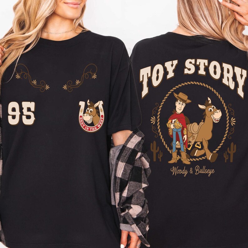 May include: Black t-shirt featuring a cartoon design from Toy Story. The front displays a horseshoe with a horse head and the number 95. The back has the words "Toy Story" above a graphic of Woody and Bullseye.
