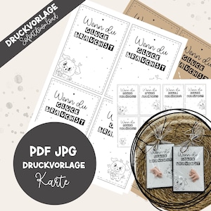 Può includere: Un modello digitale stampabile con carte rettangolari che riportano il testo tedesco Wenn du GLÜCK BRAUCHST e un disegno al tratto di un maialino che tiene un trifoglio. Il design include un bordo tratteggiato e piccoli cuori, in formato PDF e JPG.
