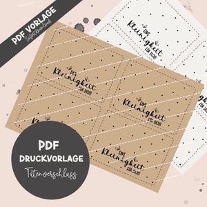 May include: A digital PDF template featuring rectangular tags with the text "Eine Kleinigkeit für Dich" in black script. The tags are on a tan and white dotted background, with a dark gray circle and text "PDF DRUCKVORLAGE".