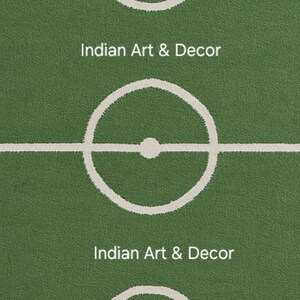 Puede incluir: Alfombra verde con dise&ntilde;o de campo de f&uacute;tbol, con l&iacute;neas y marcas blancas. El texto "Indian Art & Decor" se muestra en blanco. La alfombra tiene un aspecto texturizado.