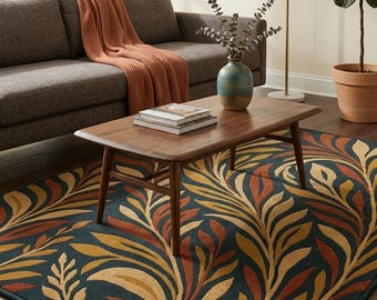 May include: A rectangular area rug with a botanical design. The rug features a dark teal background with a pattern of stylized leaves in shades of gold, orange, and rust. The rug is placed in a living room setting.