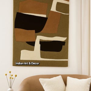 May include: Abstract wall art with a geometric design in shades of brown, black, and cream. The artwork is rectangular and hangs on a white wall. The text "Indian Art & Decor" is visible at the bottom of the artwork.