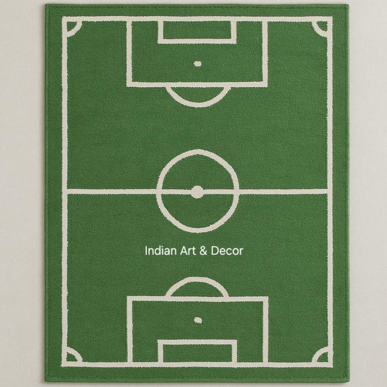 Puede incluir: Alfombra rectangular verde con un dise&ntilde;o de campo de f&uacute;tbol blanco. La alfombra presenta un contorno detallado del campo, incluyendo el c&iacute;rculo central, las &aacute;reas de penalti y las marcas de esquina. El texto "Indian Art & Decor" est&aacute; en la parte inferior.