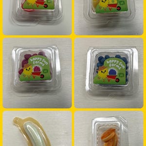 May include: Five clear plastic containers with different fruit gummies inside. Each container has a colorful sticker with a cartoon character and the words "Happy Sun Farms".