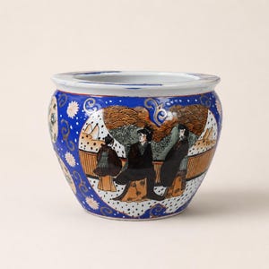 May include: A ceramic bowl featuring a vibrant blue background with white floral accents and gold scrollwork. The exterior displays circular panels depicting figures in traditional attire within a landscape, set against a white rim and base.