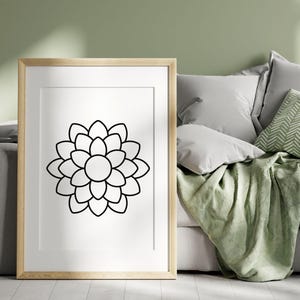 Pode incluir: Um desenho a preto e branco de uma flor com m&uacute;ltiplas p&eacute;talas, emoldurado numa moldura de madeira clara. A moldura est&aacute; sobre uma superf&iacute;cie branca.