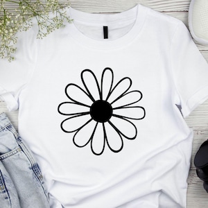 Pode incluir: Camiseta branca com um gr&aacute;fico de margarida preta.