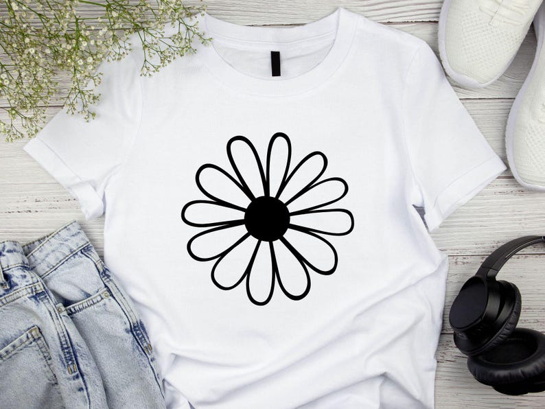 Pode incluir: Camiseta branca com um gr&aacute;fico de margarida preta.