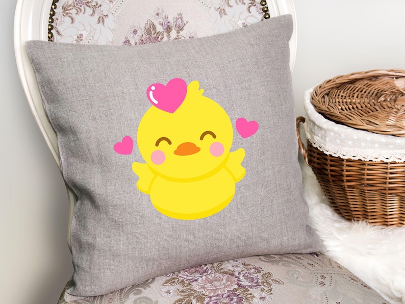 May include: A gray pillow with a yellow chick with pink hearts on a gray background.