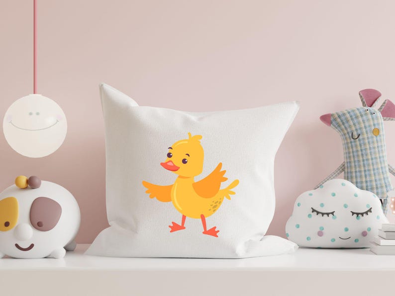 May include: White pillow with a yellow duckling cartoon illustration. The duckling is facing right and has a red beak and orange feet.
