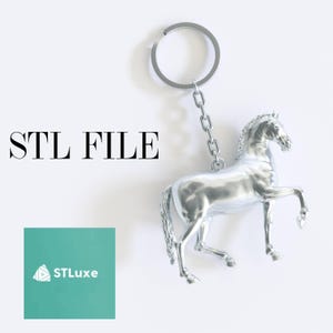 May include: A silver horse keychain with a key ring. The horse is standing on its hind legs with its front legs raised. The keychain is labeled "STL FILE".